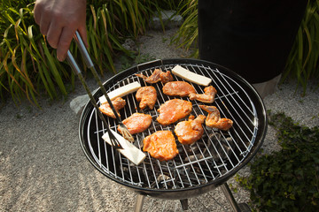 Person putting cheese on a BBQ grill