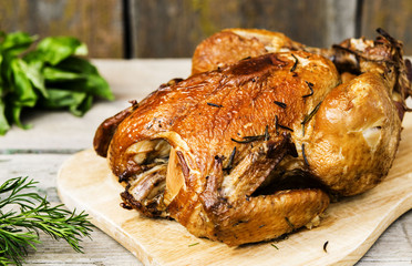 Smoked chicken with herbs on vintage wooden background 