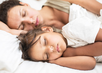 Fototapeta na wymiar Sleeping kid girl and her mother in the bed.