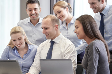 smiling business people with laptop computer