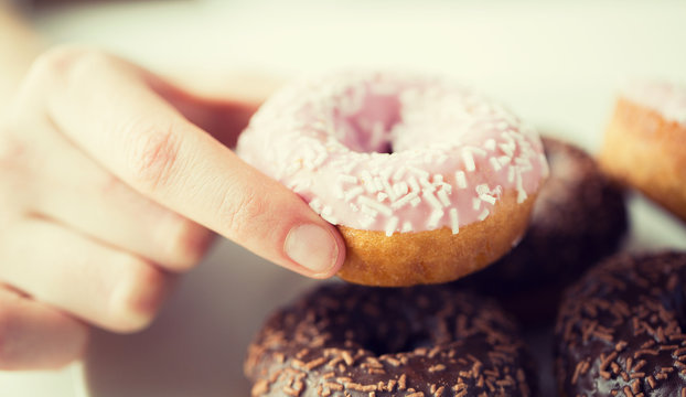 Close Up Of Hand Holding Glazed Donut