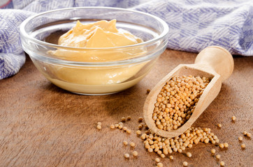 mustard seeds on a wooden shovel and mild mustard