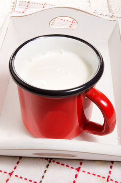 warm milk in a red enamel mug