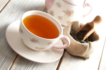 Cup of tea, teapot and dried leaves of tea in bag