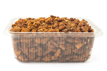 Box or punnet of domestic salty fried pork greaves, cvarci, on plate isolated on white