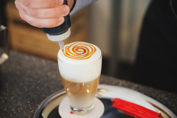 Barista creates a picture in a cup of coffee latte