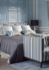 Light blue romantic style bedroom with reading lamp and comfortable sofa