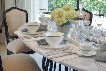 dining table and comfortable chairs in modern home with elegant table setting