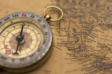 Fototapeta na wymiar Old compass on vintage map selective focus on Mexico