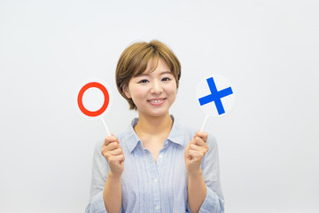 ◯☓プレートを持つ若い女性