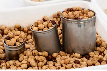 Seller of Peanuts / Close Up of the sales counter of peanuts with small tin cans.