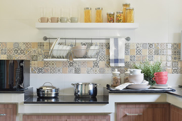 Naklejka na ściany i meble modern ceramic kitchenware and utensils on the black granite counter top