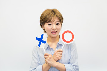 ◯☓プレートを持つ若い女性