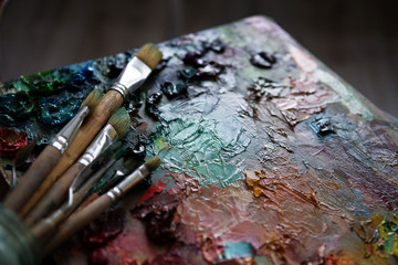 artists brushes and oil paints on wooden palette