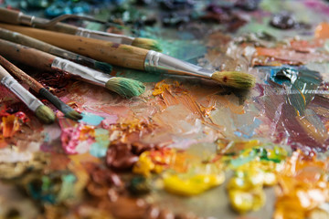 Fototapeta premium artists brushes and oil paints on wooden palette