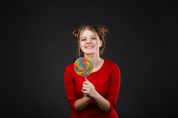 Portrait of a smiling young beautiful girl in a red dress with a