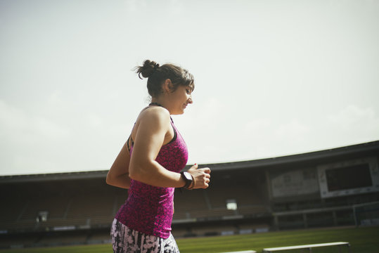 Woman running on a stadium