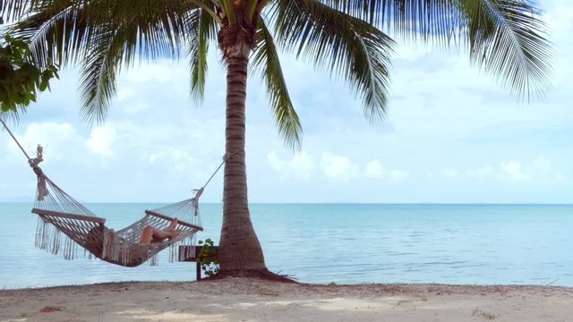 Woman in hammock on the beach. Zoom in