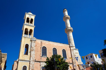 Obraz premium Orthodox church with a bell tower and minaret in the town of Chania, Crete.