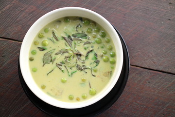 green curry in white bowl on wooden table Thailand