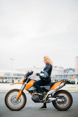 Young woman at motorcycle holding map
