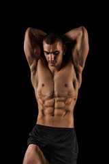 Fototapeta na wymiar Sexy Athletic Man showing six pack abs. Isolated on black background with copy space