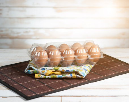 fresh eggs in plastic container on wood background,morning light