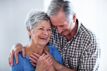 Happy senior couple smiling while embracing