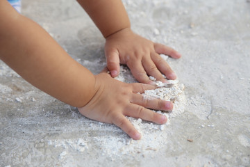 baby's hand playing on the ground