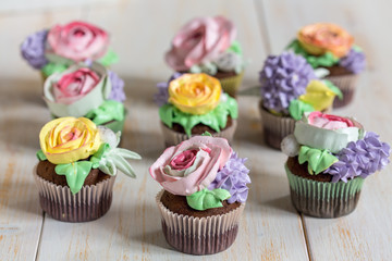 Chocolate cupcakes with cream-colored flowers.