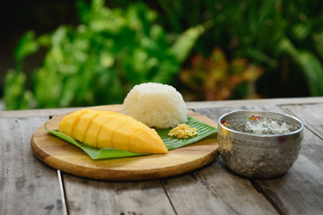 Mango sticky rice on wooden plate
