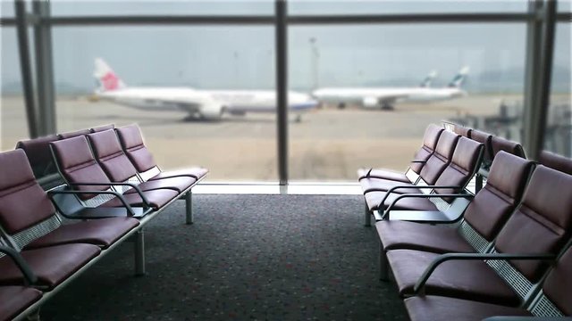 Close-up chairs in the airport, on the background of a moving airplane.
