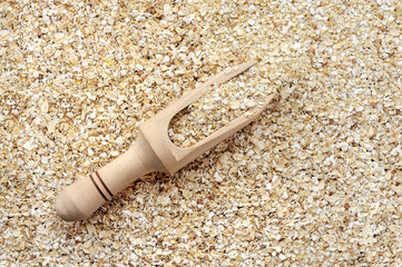 Oat flakes in wooden scoop as background or texture