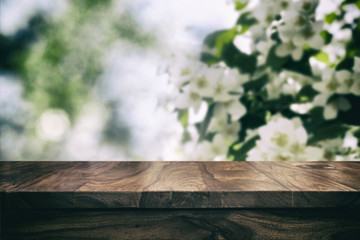 Empty top wooden table and floral blurred background