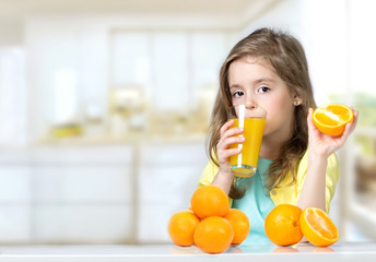 Child girl drinking fresh orange juice background.