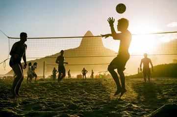 Fototapeten Silhouetten von Brasilianern, die bei Sonnenuntergang am Strand von Ipanema in Rio de Janeiro, Brasilien, Strand Futevolei (Fußvolley) spielen, eine Sportart, die Fußball (Fußball) und Volleyball kombiniert © lazyllama
