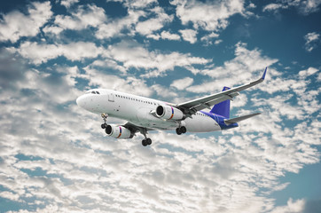 Fototapeta na wymiar Airplane flying on blurred blue sky