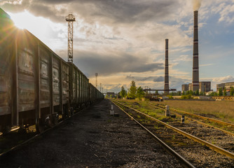 Fototapeta premium Coal power station with cloudy sunset sky train.