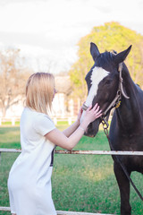 Obraz premium young woman petting a beautiful horse