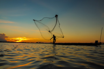 Fisherman through the net in the river.Thailand.