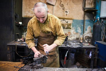 The wizard removes the excess weld using a power saw with a metal layout of a construction crane