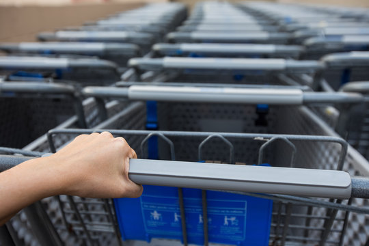 Woman taking shopping cart near supermarket