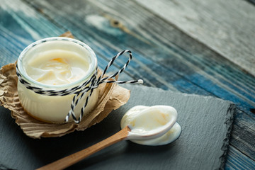 Jar with fresh yogurt on a rustic table