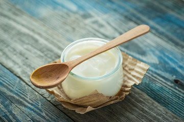 Jar with fresh yogurt on a rustic table