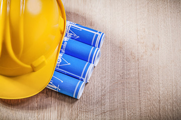 Wooden board with blue rolled up construction drawings building 
