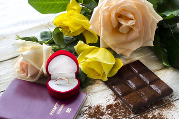 Marriage proposal with gold ring in the red hearth box and passport