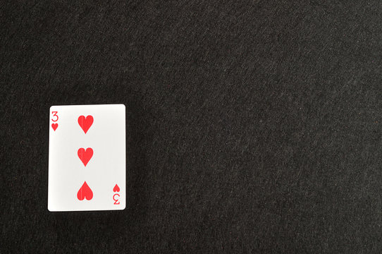Playing card. Three of hearts isolated on a black background