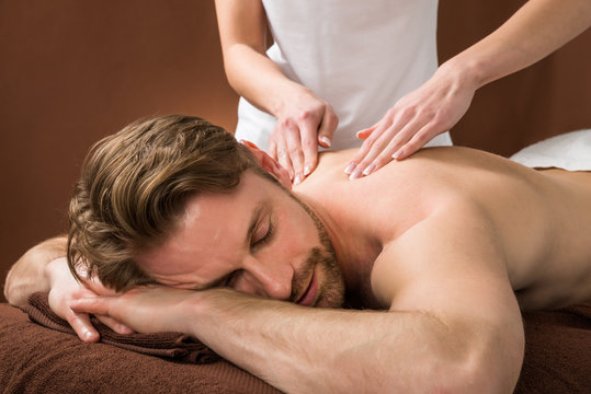 Young Man Receiving Back Massage At Spa