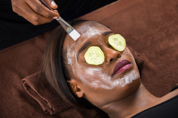 Woman Applying Facial Mask In Spa
