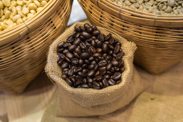 A coffee bean in a container with both roasted and raw. Represent a fresh and scent of coffee.